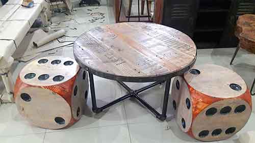 Table basse ronde en mobilier industriel avec deux dés tabourets.